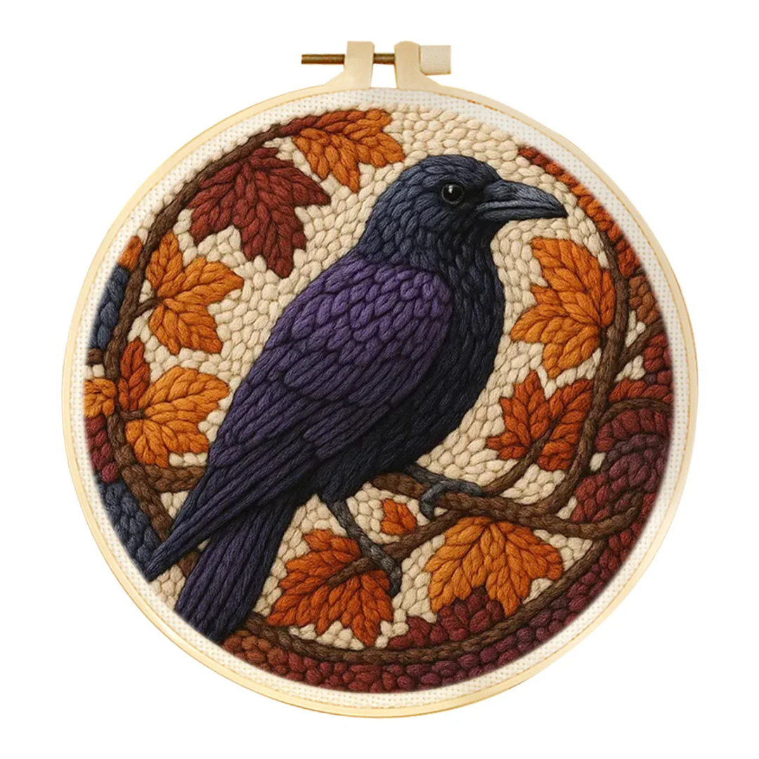 Embroidery hoop with a bird and autumn leaves design on a white background
