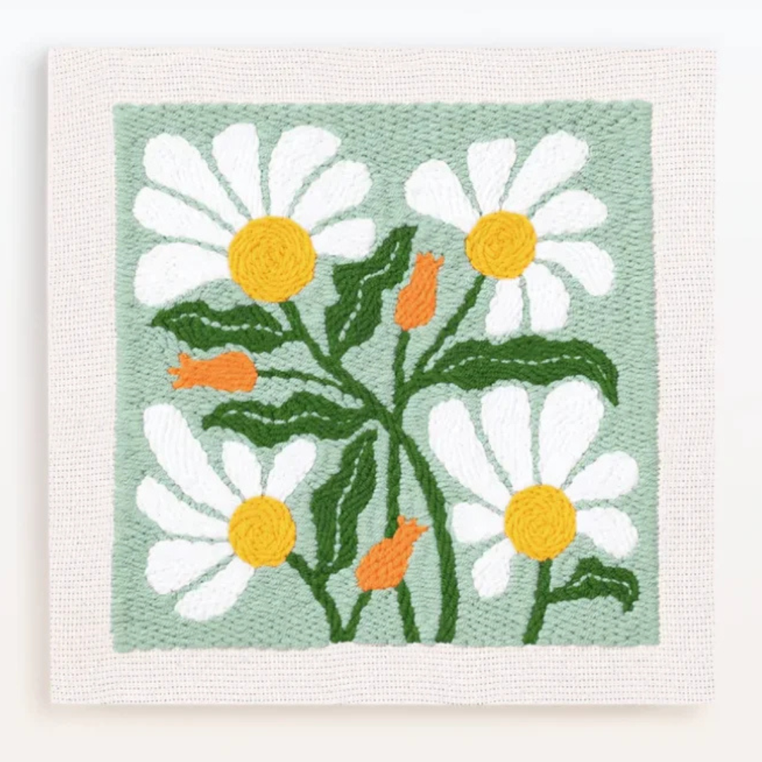 Embroidered patch with daisies on a light green background