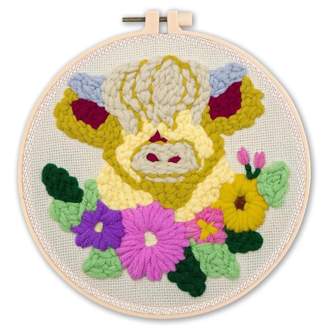 Embroidery hoop with a colorful embroidered design of a bear surrounded by flowers on a white background