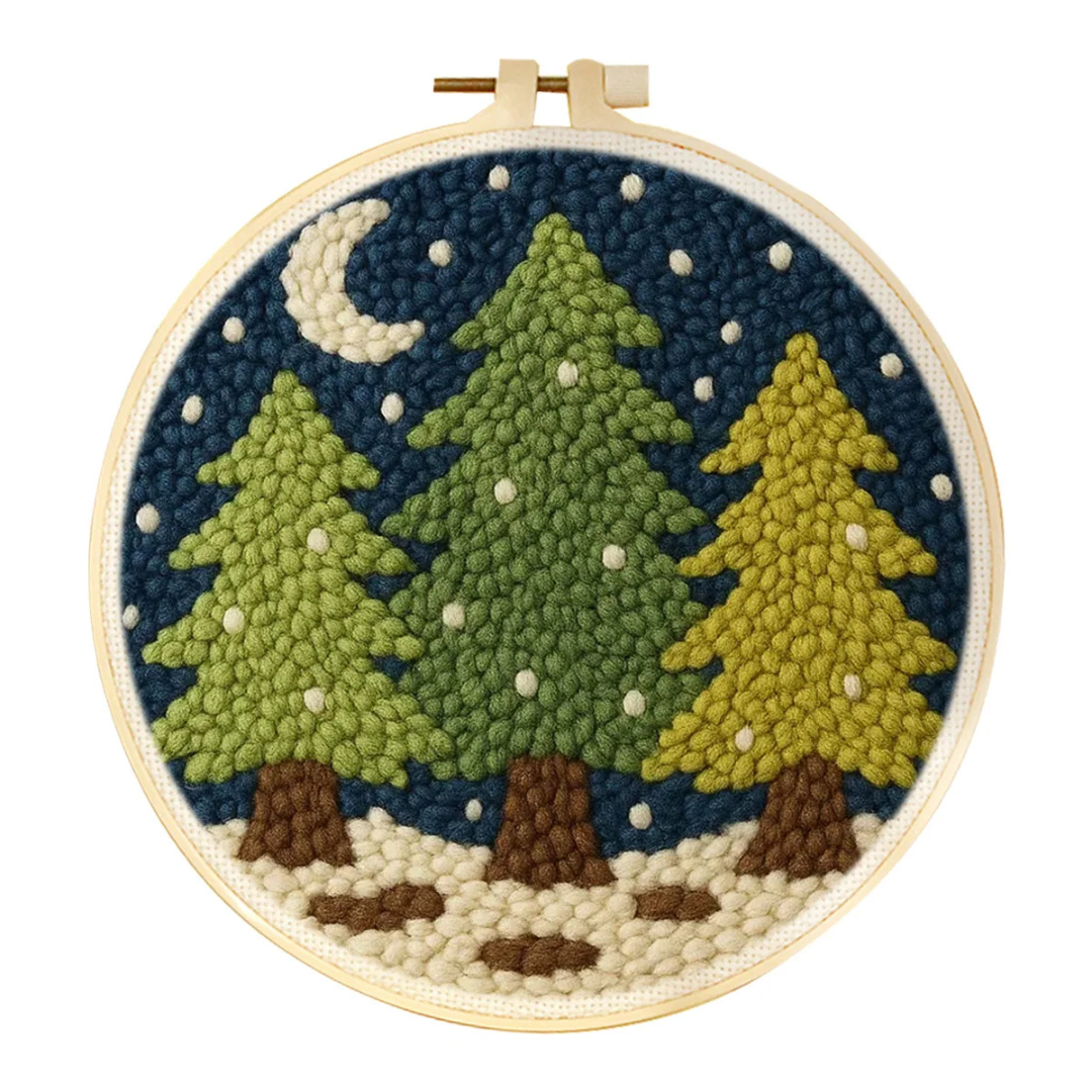 Embroidery hoop with a winter forest scene including trees, moon, and snow.