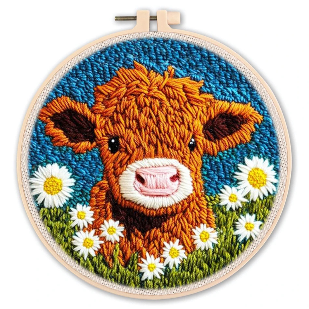 Embroidery hoop with a cow and daisy design on a white background