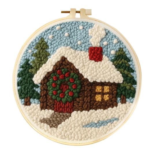 Embroidery hoop with a winter scene of a cabin and trees.