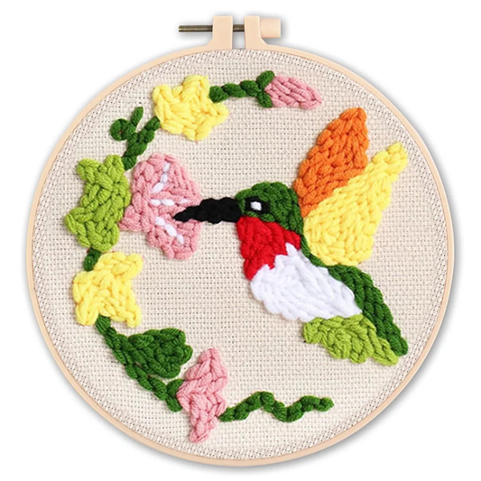 Embroidery hoop with a colorful knitted hummingbird and flowers on a white background