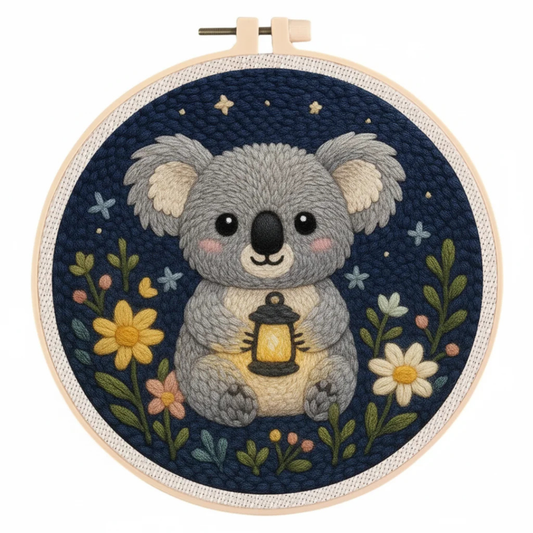 Embroidery hoop with a koala holding a lantern and flowers on a dark blue background