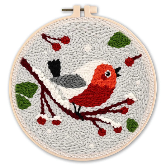 Embroidery hoop with a red bird on a branch design against a gray background