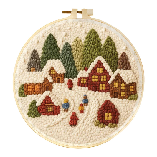Embroidery hoop with a winter village scene including houses and trees.